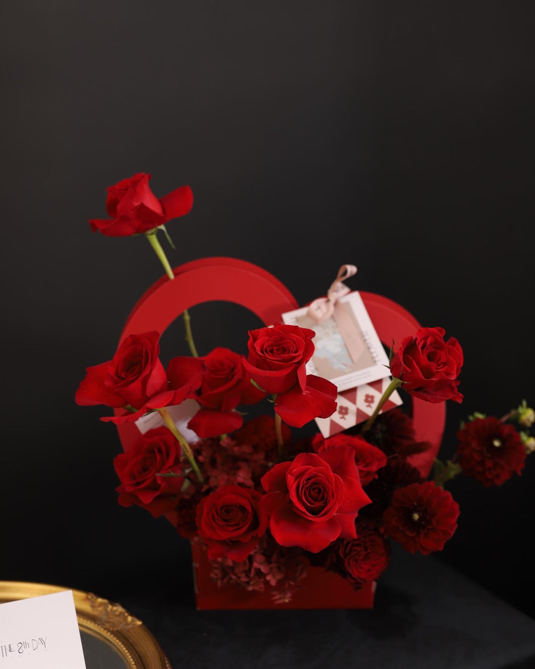 heart-shaped flower arrangement featuring red roses