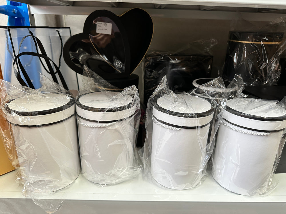 white hat boxes, each still wrapped in plastic