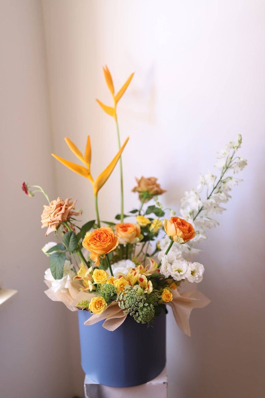 flower arrangement in a round, blue hat box
